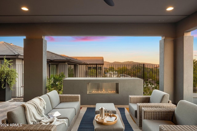 patio terrace at dusk with an outdoor living space with a fireplace