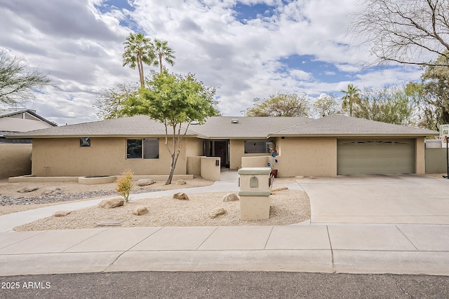 view of front of house with a garage, concrete driveway, and stucco siding