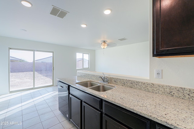 kitchen featuring light tile patterned floors, ceiling fan, dishwasher, light stone counters, and sink