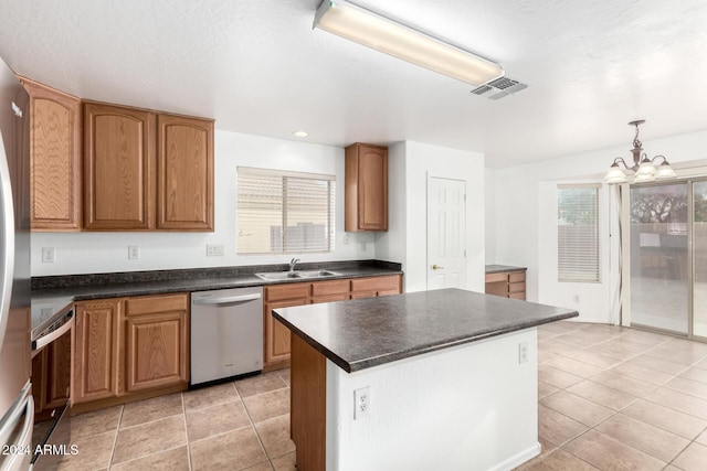 kitchen with plenty of natural light, a center island, stainless steel dishwasher, and decorative light fixtures