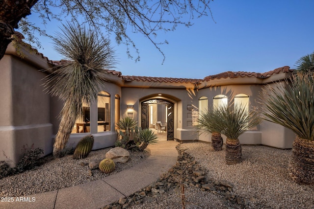 mediterranean / spanish-style house featuring a tile roof and stucco siding