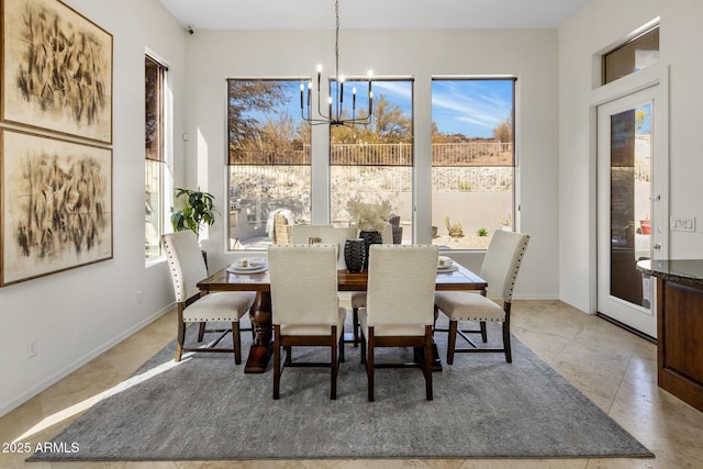 dining space with baseboards and an inviting chandelier