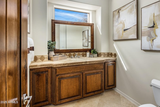 half bathroom with baseboards, tasteful backsplash, toilet, and vanity