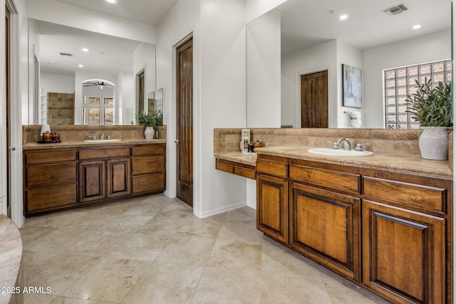 full bath with visible vents, recessed lighting, two vanities, and a sink