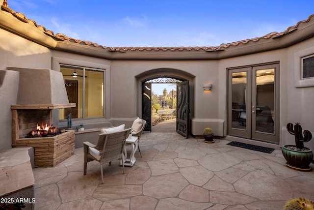 view of patio / terrace with french doors and a multi sided fireplace