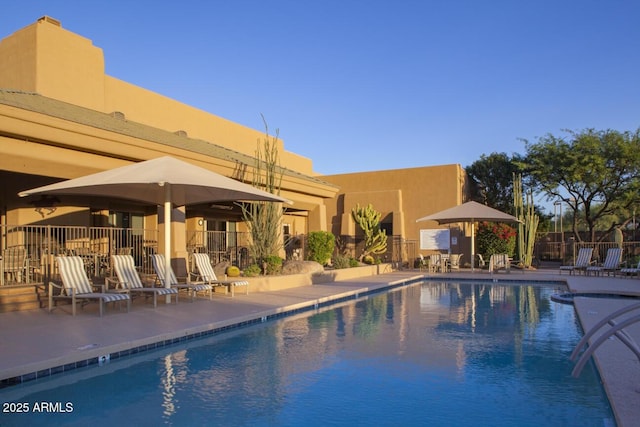 pool with a patio and fence