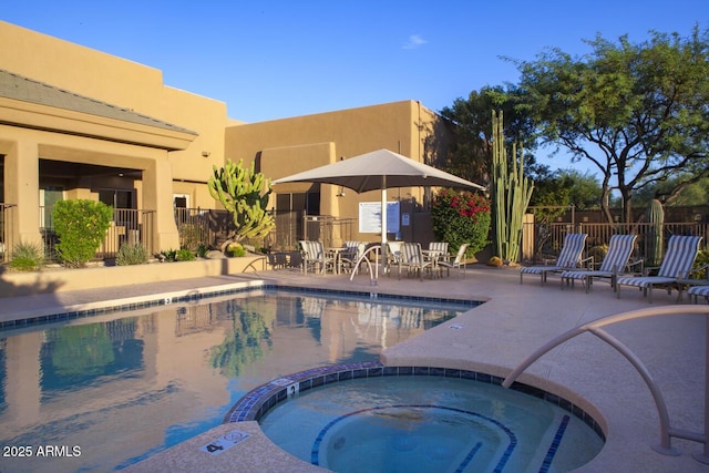 view of swimming pool featuring a patio area, a community hot tub, and fence