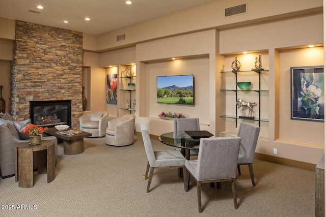 dining space featuring carpet flooring, a fireplace, and visible vents