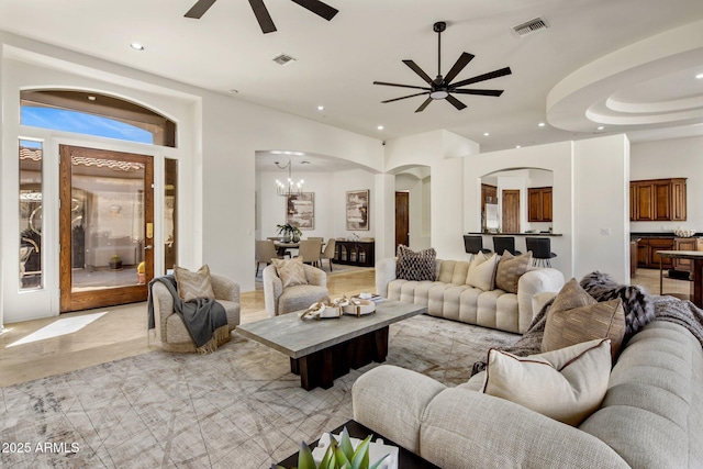 living area with recessed lighting, a ceiling fan, visible vents, and arched walkways