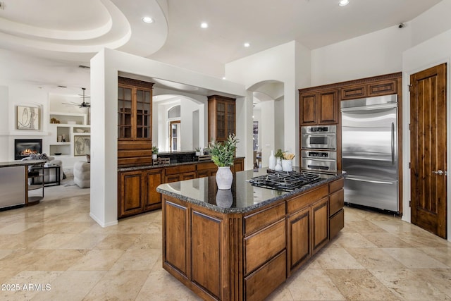 kitchen with arched walkways, recessed lighting, appliances with stainless steel finishes, and a ceiling fan