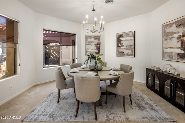 dining room with visible vents, baseboards, light colored carpet, and an inviting chandelier