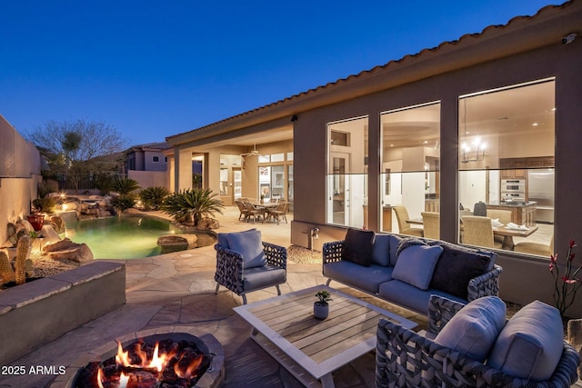 view of patio / terrace with an outdoor living space with a fire pit and outdoor dining area