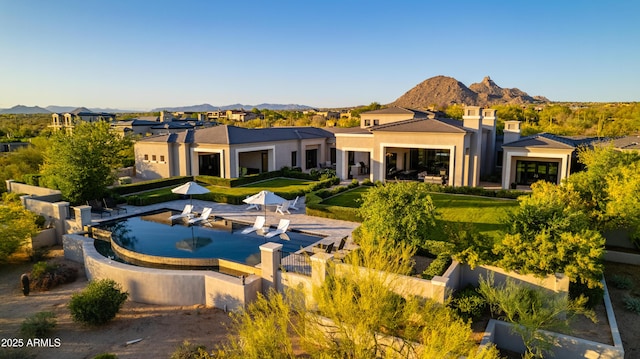 back of property featuring a residential view, stucco siding, a fenced in pool, a mountain view, and fence private yard