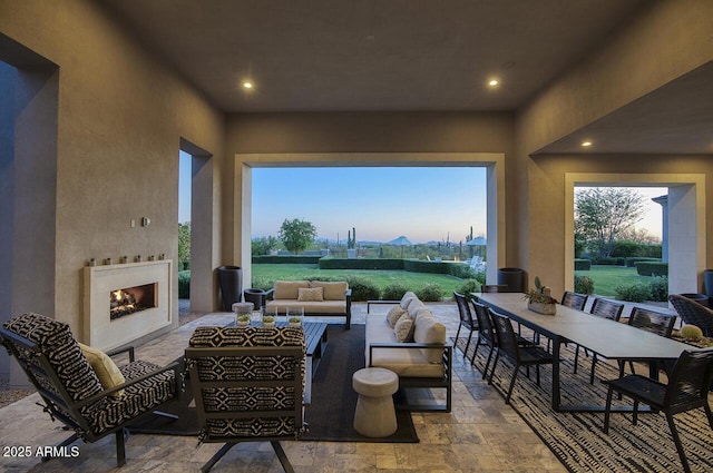 view of patio with an outdoor living space with a fireplace and outdoor dining space
