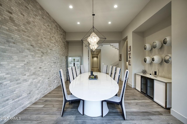 dining area with stairs, recessed lighting, brick wall, and wood finished floors