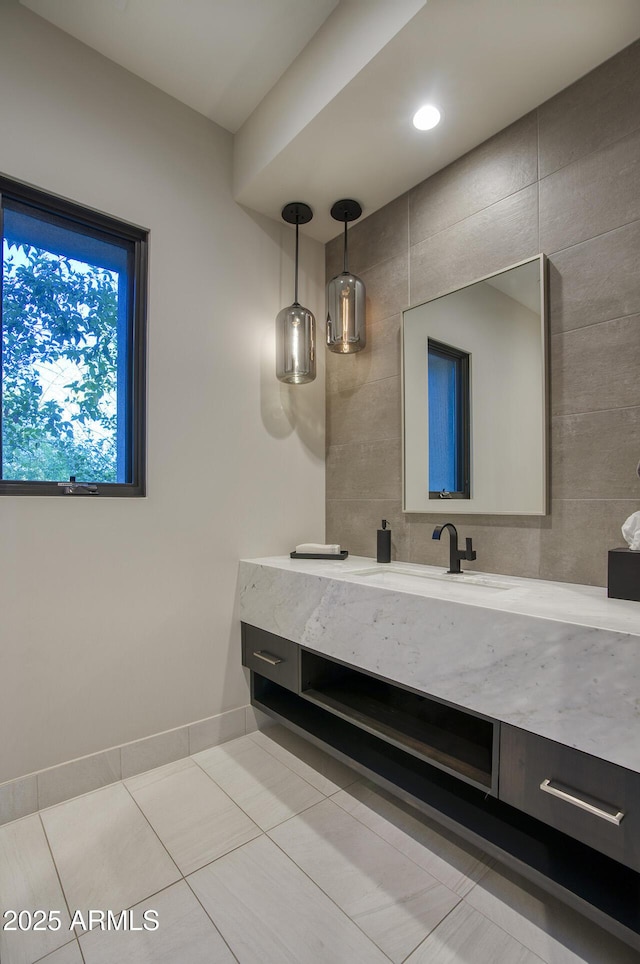 bathroom with vanity, baseboards, and tile patterned floors