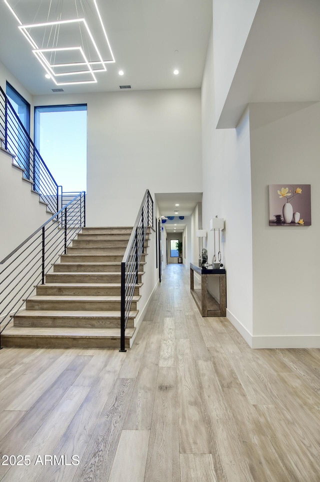 entrance foyer featuring visible vents, wood finished floors, baseboards, stairway, and recessed lighting