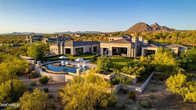 rear view of property featuring a residential view, a mountain view, and stucco siding