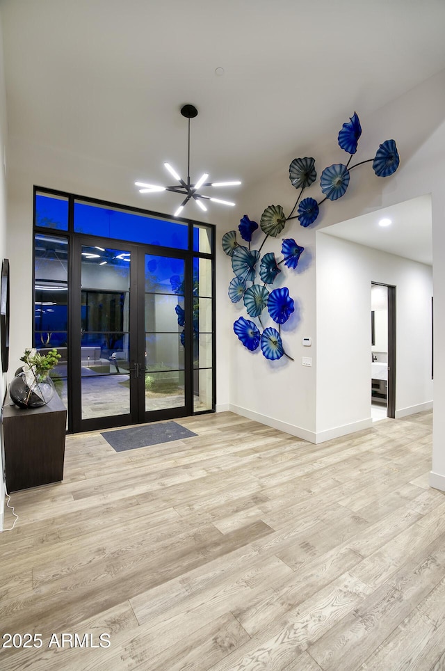 interior space with an inviting chandelier, wood finished floors, baseboards, recessed lighting, and french doors