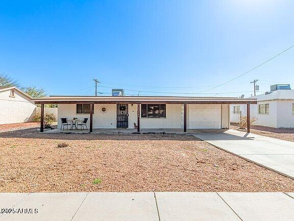 11305 W Alabama Ave, Youngtown, AZ 85363 - single story home featuring a carport, driveway, a porch, and an attached garage