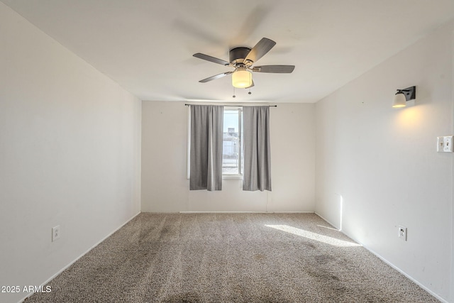 carpeted empty room with a ceiling fan