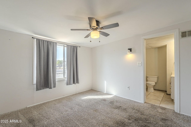 empty room featuring ceiling fan, visible vents, and light colored carpet