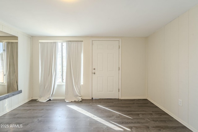 foyer entrance featuring baseboards and wood finished floors