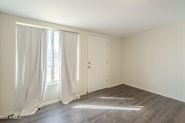 foyer featuring baseboards and wood finished floors