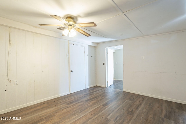 empty room featuring a ceiling fan, baseboards, and wood finished floors