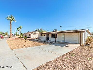 ranch-style house featuring a garage, concrete driveway, and covered porch