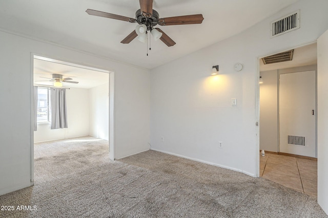 spare room with visible vents, carpet flooring, and tile patterned floors