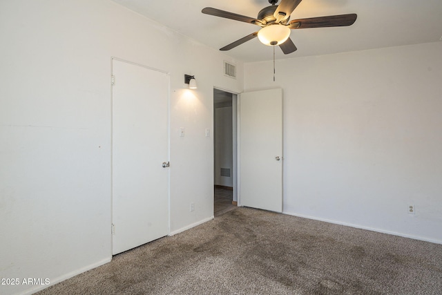 spare room featuring carpet, visible vents, and a ceiling fan