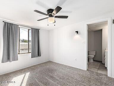 carpeted empty room featuring visible vents and ceiling fan