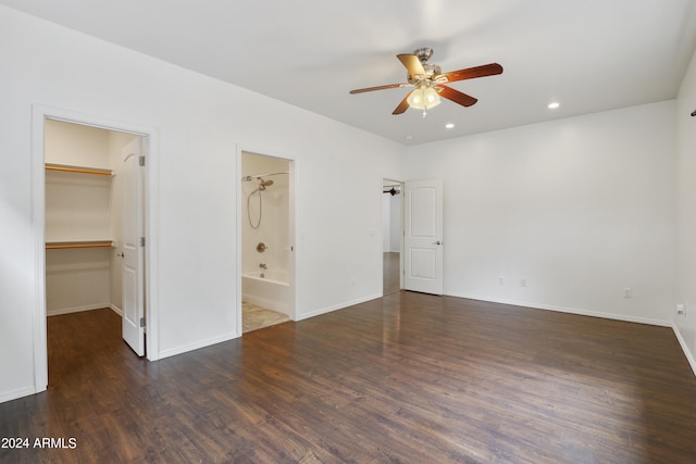 unfurnished bedroom featuring ceiling fan, hardwood / wood-style flooring, a walk in closet, connected bathroom, and a closet