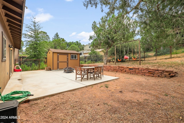 view of patio featuring an outdoor fire pit and a storage unit