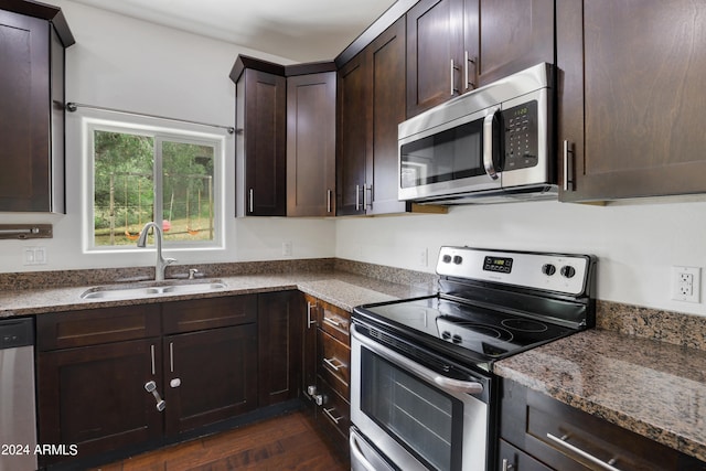 kitchen with dark brown cabinets, sink, dark wood-type flooring, and stainless steel appliances