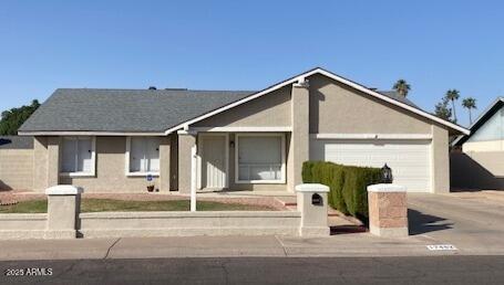 ranch-style home featuring a garage, concrete driveway, and stucco siding