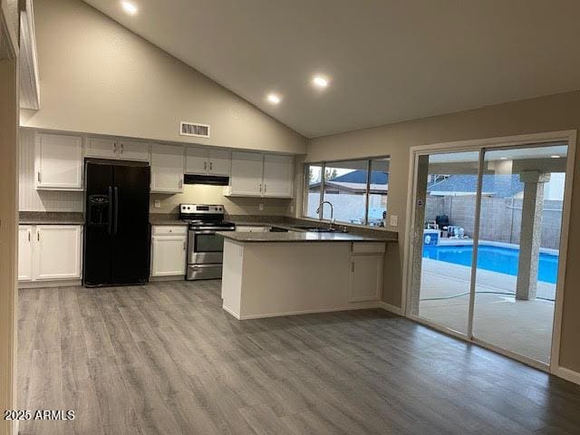 kitchen featuring visible vents, electric stove, black refrigerator with ice dispenser, under cabinet range hood, and a sink