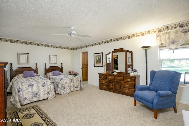 bedroom featuring a textured ceiling, ceiling fan, and carpet