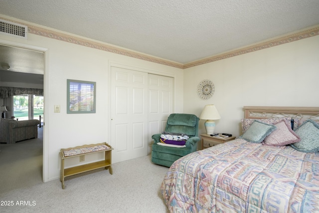 carpeted bedroom featuring a textured ceiling, a closet, and crown molding