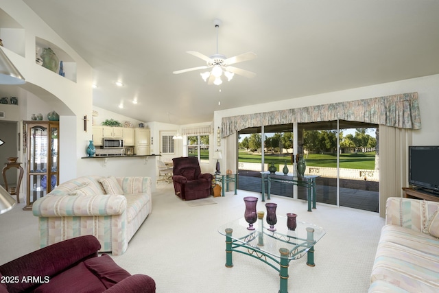 living room with ceiling fan, vaulted ceiling, and carpet flooring