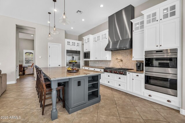 37308 N 100th Pl, Scottsdale, AZ 85262 - kitchen featuring decorative backsplash, wall chimney range hood, built in appliances, visible vents, and light tile patterned flooring