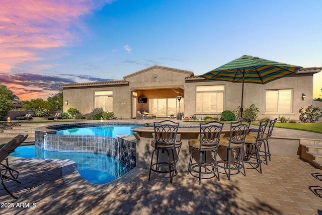 37308 N 100th Pl, Scottsdale, AZ 85262 - pool at dusk with outdoor dry bar, a pool with connected hot tub, and a patio area