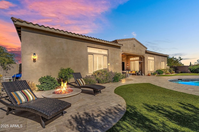 37308 N 100th Pl, Scottsdale, AZ 85262 - rear view of house featuring a patio area, a fenced in pool, a yard, a fire pit, and stucco siding
