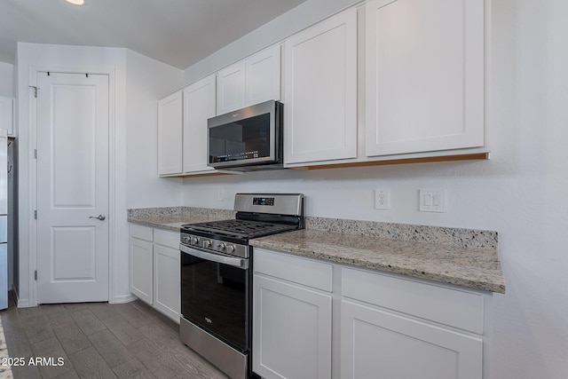 6117 S Adelle, Mesa, AZ 85212 - kitchen with white cabinets, light stone counters, stainless steel appliances, baseboards, and dark wood-type flooring