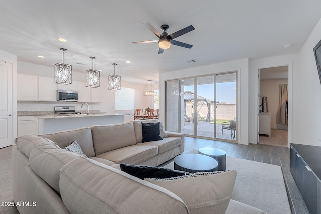 6117 S Adelle, Mesa, AZ 85212 - living area featuring recessed lighting, light wood-style floors, ceiling fan with notable chandelier, and visible vents