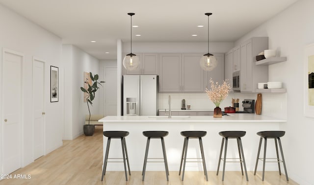 kitchen with gray cabinets, white fridge with ice dispenser, pendant lighting, and black range oven