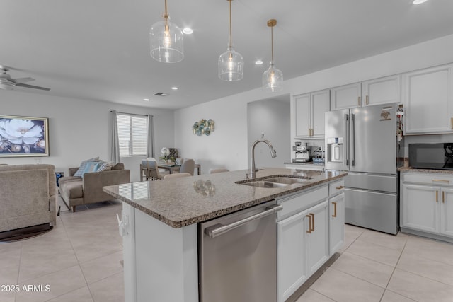 kitchen with appliances with stainless steel finishes, a center island with sink, white cabinetry, and sink