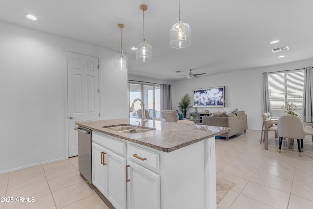 kitchen featuring stainless steel dishwasher, ceiling fan, sink, white cabinets, and an island with sink