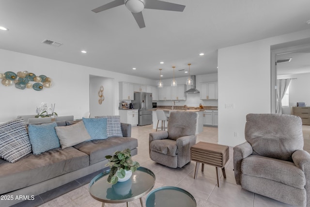 living room with ceiling fan, sink, and light tile patterned floors